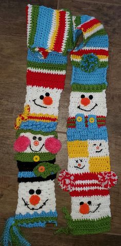 crocheted snowman scarf on wooden floor next to it's matching hat and scarf