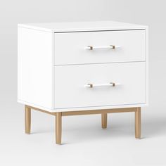 a white cabinet with two drawers sitting on top of it's legs and one drawer open