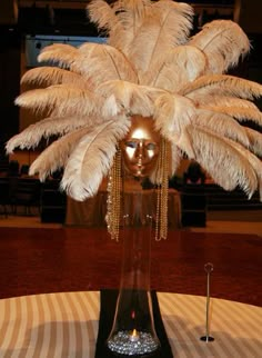 a table topped with a vase filled with feathers