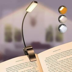 an open book sitting on top of a table next to a light that is turned on