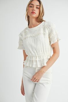 This white peplum top features a stylish mix of ruffled and smocked details, along with short puff sleeves. Elevate your wardrobe with this versatile piece, perfect for both casual and formal occasions. round neckline lined smocked 100% polyester Luxury Elegant Smocked Top, Affordable White Short Sleeve Smocked Top, Luxury Smocked Top With Gathered Sleeves For Spring, Cheap Spring Smocked Top With Smocked Cuffs, Cheap Summer Smocked Top With Smocked Cuffs, Cheap Stretch Smocked Top With Smocked Bodice, Luxury Chic Smocked Top, Chic Smocked Top For Spring, Luxury White Tops With Smocked Bodice