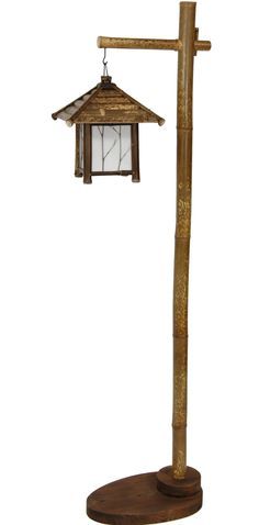 a lamp that is sitting on top of a pole with a bird feeder hanging from it's side