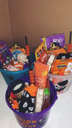 three plastic buckets filled with halloween treats