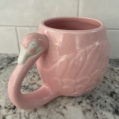 a pink flamingo mug sitting on top of a marble counter