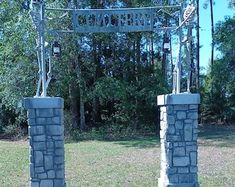 two statues are standing in front of a sign that says welcome to the skeleton man