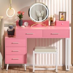 a pink desk with drawers and a mirror