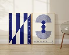 two blue and white posters on the wall next to a glass table in a room