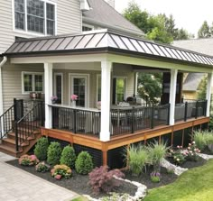 a small house with a deck and landscaping around it