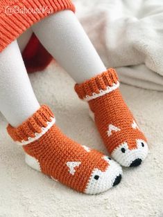 a close up of a child's legs wearing knitted socks with foxes on them