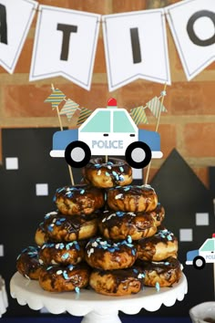 donuts stacked on top of each other in front of a police car cake stand