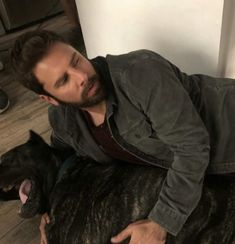 a man laying on the floor with his dog