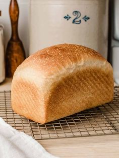 a loaf of bread sitting on top of a cooling rack next to a canister