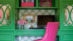 a pink chair sitting in front of a green desk