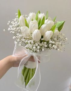 a bouquet of white tulips and baby's breath