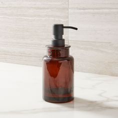 a brown soap dispenser sitting on top of a white marble countertop