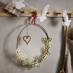 a circular metal decoration hanging on a wall next to clothes pins and paper cutouts