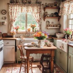 a kitchen with flowers on the window sill and table in front of the stove