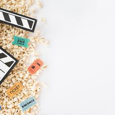 popcorn and movie claps are scattered on the white surface, next to each other