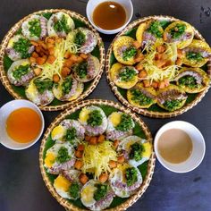 three plates filled with different types of food next to cups and sauces on a table