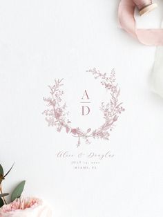 the wedding stationery is laid out next to some flowers