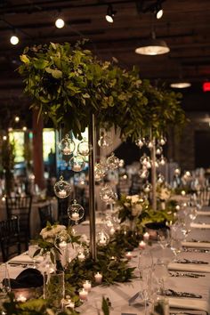 a long table with candles and greenery on it