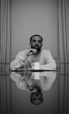 a man sitting at a table with his hand on his chin