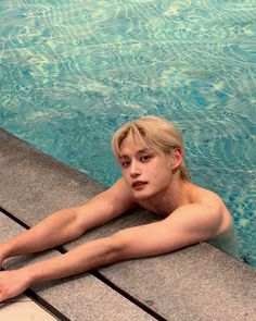 a man laying on the edge of a swimming pool