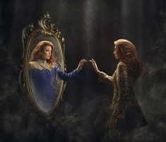 two women touching hands in front of a mirror