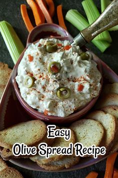 easy olive spread recipe in a bowl with crackers and carrots