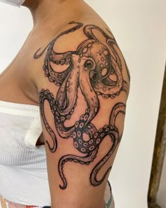 an octopus tattoo on the arm and shoulder