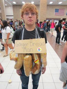 a young boy is holding bread in front of him and has a sign that says ginger bread man