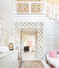 a living room with white walls and wooden stairs leading up to the second floor area