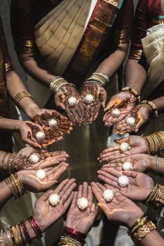 many hands are arranged in the shape of a circle with pearls on them, all around each other