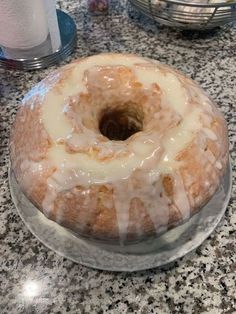 a glazed donut sitting on top of a glass cake plate next to a bottle of milk