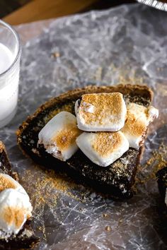 toasted bread topped with marshmallows and brownie crumbs next to a glass of milk