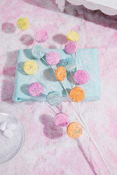 there are candy lollipops and marshmallows on the pink carpet