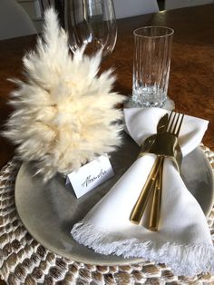 a place setting with napkins, silverware and a fur ball on the table