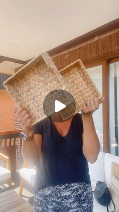 a woman is holding up a basket on her head