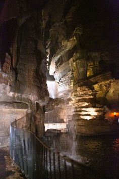 the entrance to an underground cave with stairs leading up to it and water running down the side