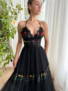 Discover timeless elegance and whimsical charm with our black tulle dress, meticulously crafted with a delicate dotted pattern. Each swirl of embroidered flower breathes life into the fabric, adding a touch of playfulness. The halter strap neckline pairs seamlessly with a flattering bustier top, hugged close to showcase your silhouette. The lace-up back adds a hint of romance, while the tiered gathered long skirt cascades effortlessly in a graceful A-line, making each twirl a statement. A dress Matoshi Dress, Teuta Matoshi, Black Tulle Dress, Dark Florals, Special Occasion Gowns, Purple Floral Dress, Halter Strap, Custom Size Dresses, Black Tulle