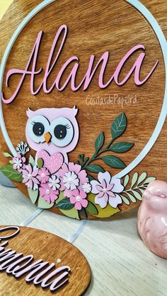 a wooden sign with an owl and flowers on it that says, almana painted in pink