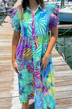 This multicolor printed dress features a collared neckline, smock detailed shoulders, frilled short sleeves, front button-up closure, side pockets, tiered, lined, and midi length. 50% Cotton 50% Rayon Hand Wash Cold. Do Not Wring Or Twist. Non Chlorine Bleach Only. Hang Dry. Low Iron As Needed. May Be Dry Cleaned. Madison is 5’8“ wearing a size Small.Model measurements:Bust: 32 in.Waist: 24 in.Hip: 34 In. Summer Midi Dress With Short Sleeves And Print, Colorful Short Sleeve Summer Dress, Colorful Summer Dress With Short Sleeves, Summer Dresses With Colorful Patterns And Short Sleeves, Multicolor Ruffled Maxi Dress For Day Out, Casual Colorful Ruffled Dresses, Colorful Ruffled Dresses For Vacation, Colorful Ruffled Vacation Dresses, Colorful Midi Dress For Vacation