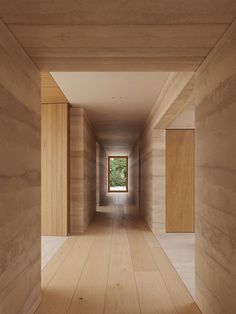 an empty hallway with wooden walls and floor to ceiling windows on either side of the room