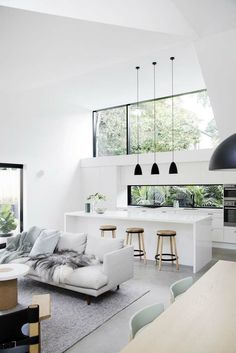 a living room filled with furniture next to a kitchen and an open concept floor plan