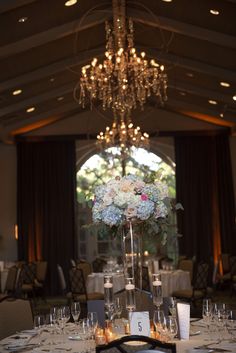 an elegant centerpiece with flowers and candles is displayed in the middle of a banquet room