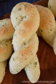 some bread rolls are on a wooden plate