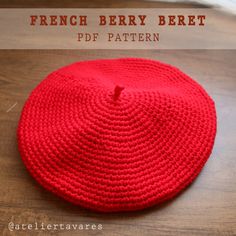 a red crocheted hat sitting on top of a wooden table with text overlay that reads, french berry beret df pattern