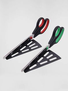 two pairs of scissors with green and red handles hanging from the side of each pair