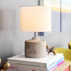 a lamp sitting on top of a stack of books