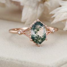 a green and white ring sitting on top of a flowery table next to flowers